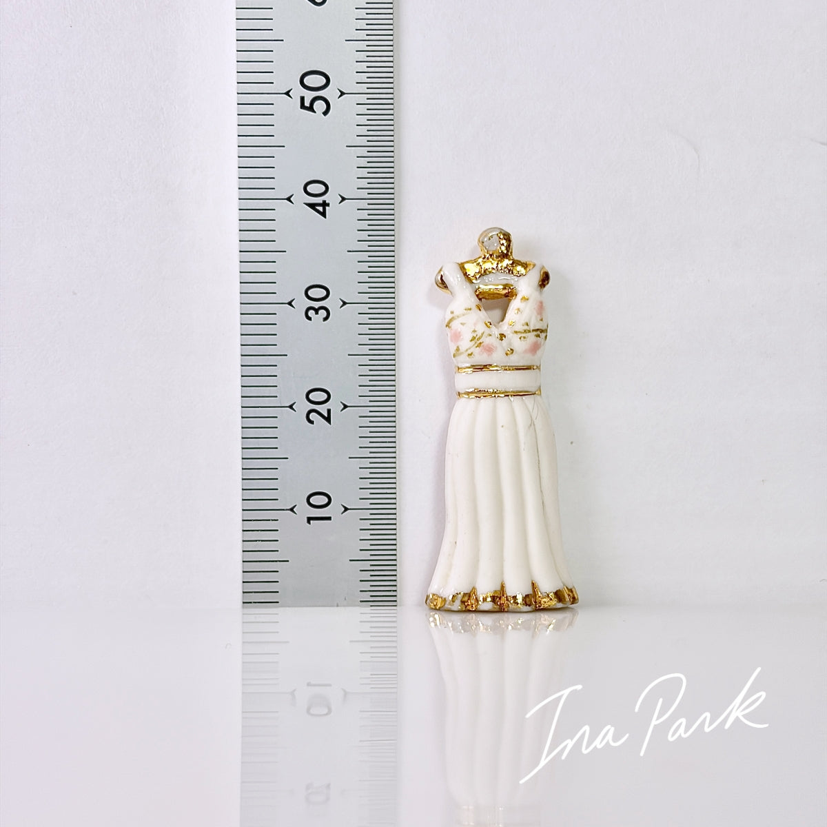 金色のハンガーにかかった白いドレスのフェーブ