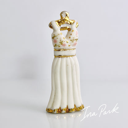 金色のハンガーにかかった白いドレスのフェーブ