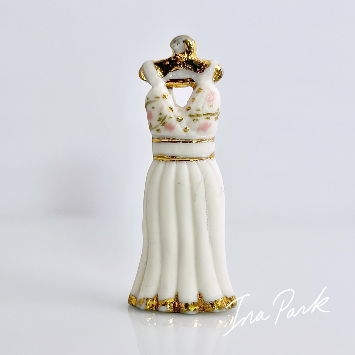 金色のハンガーにかかった白いドレスのフェーブ