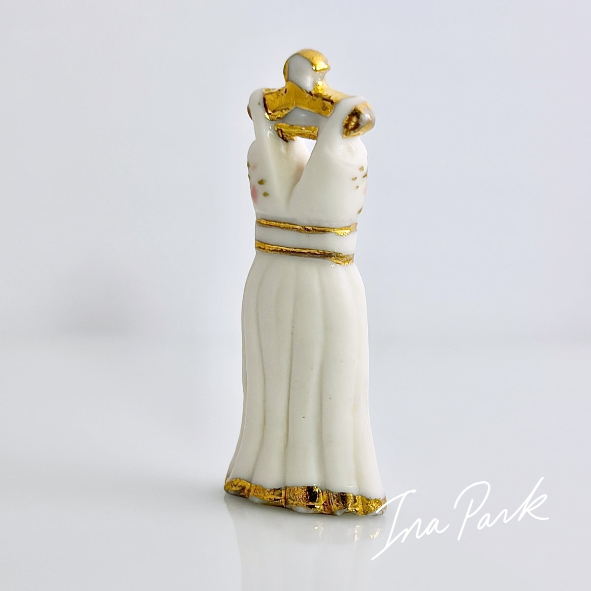 金色のハンガーにかかった白いドレスのフェーブ