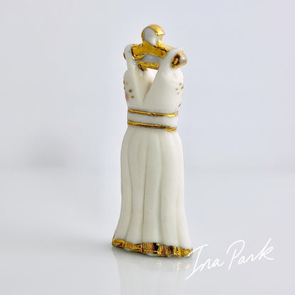 金色のハンガーにかかった白いドレスのフェーブ