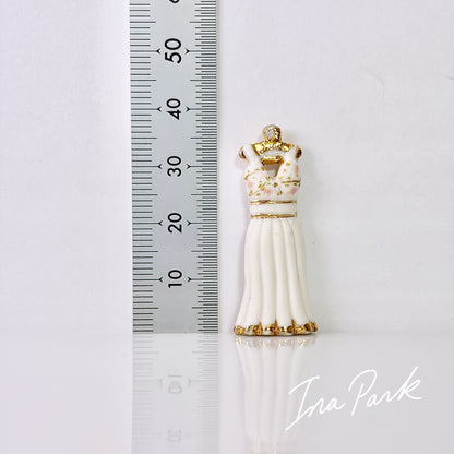 金色のハンガーにかかった白いドレスのフェーブ